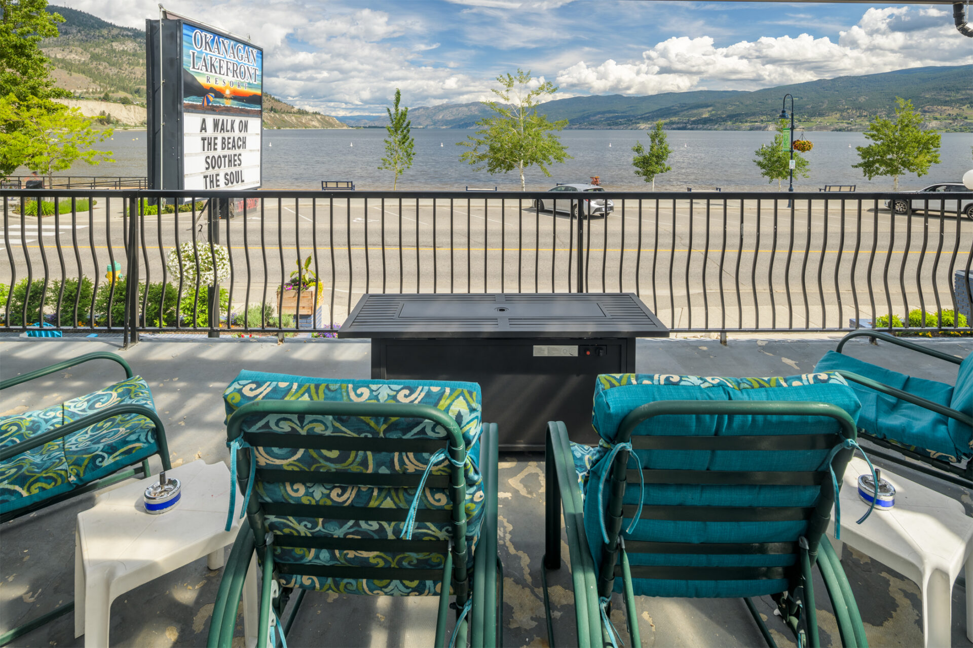 okanagan lakefront resort balcony with chairs and a firepit table to relax while taking in views of Okanagan Lake and Beach