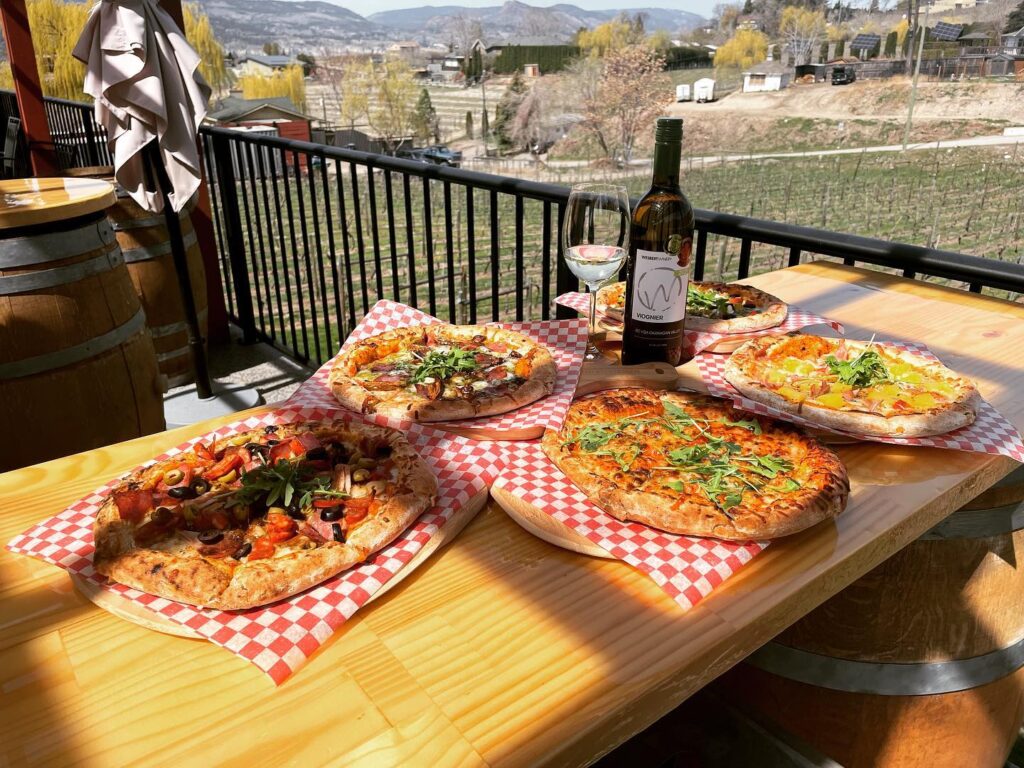 wesbert winery pizza on patio with bottle of wine
