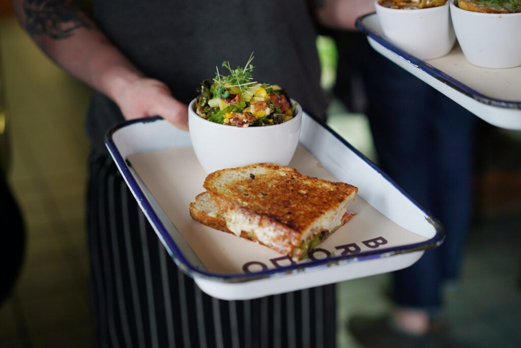 soup and sandwich plate being carried by waiter at Brodo Kitchen