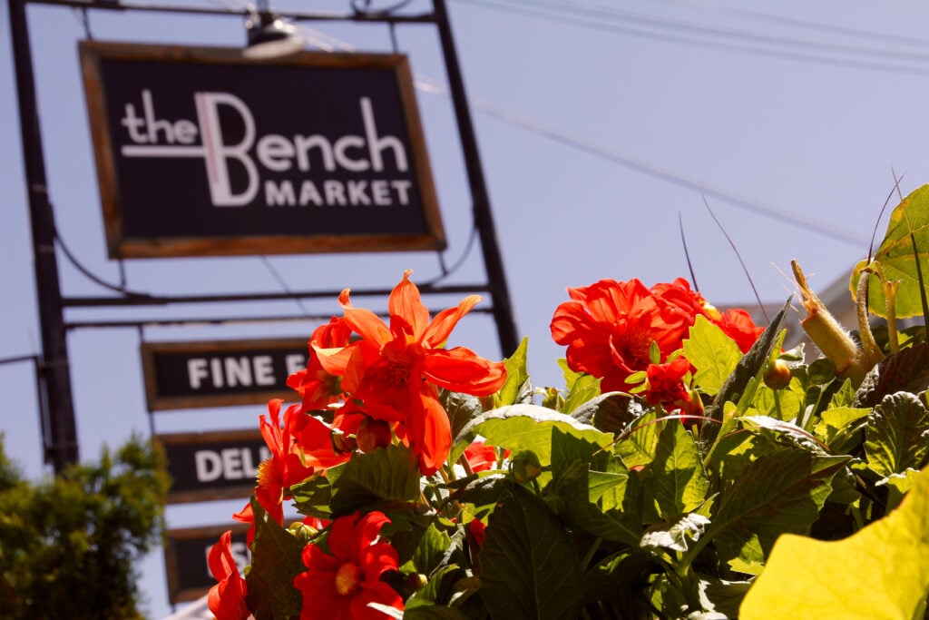 The Bench Market - Street sign with flowers in foreground