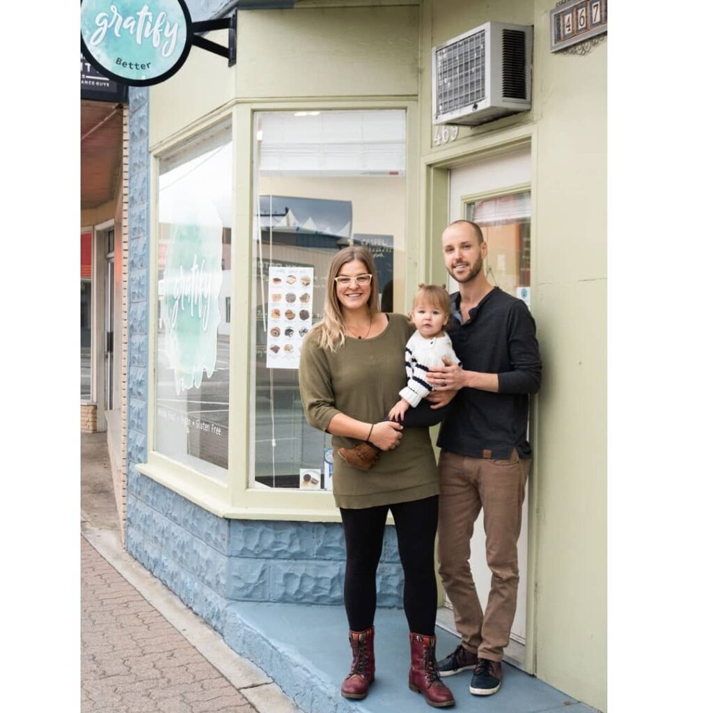 Gratify owners with baby standing out front of their storefront