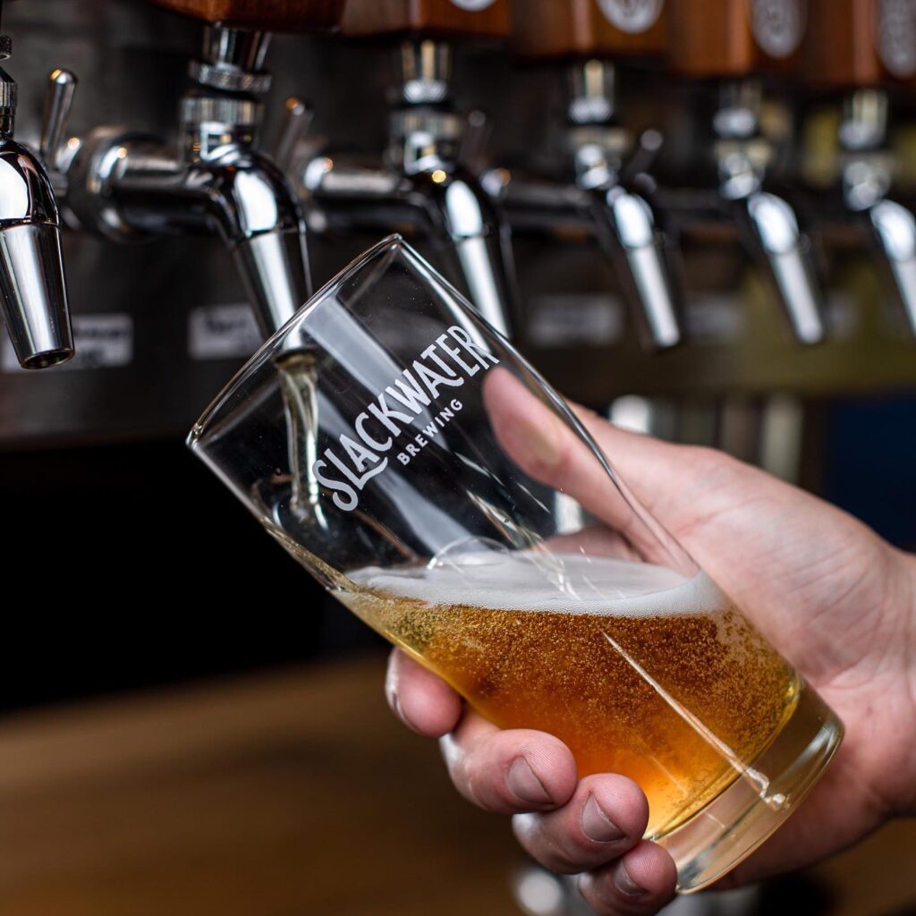 Slackwater beer being poured in a Slackwater glass