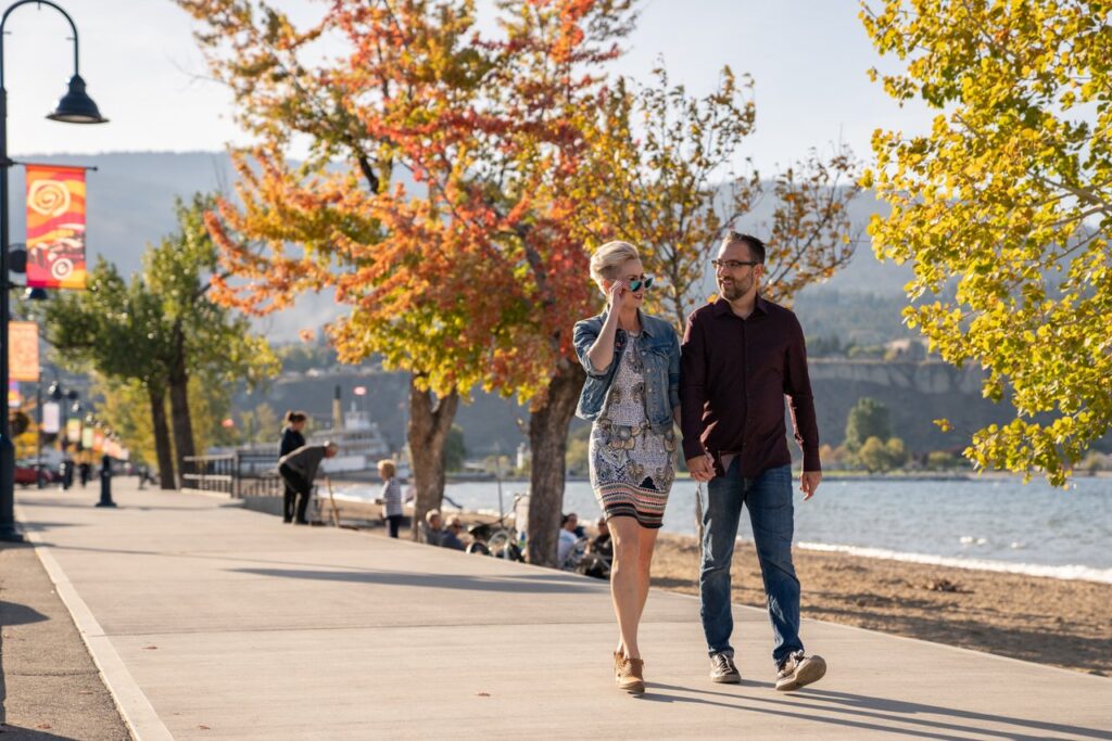 couple walking along boardwalk in penticton in fall