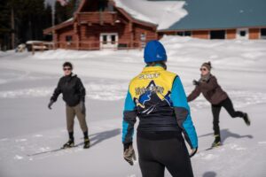 Instructor teaching a man and women how to nordic ski