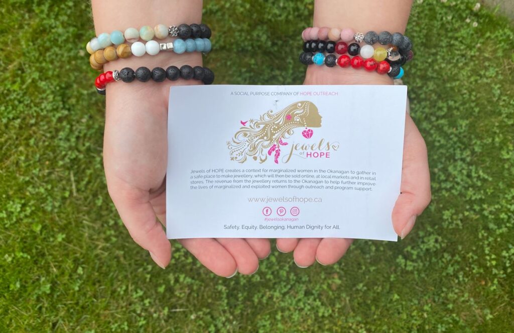 two hands with multiple bracelets on it hold a car describing the Jewels of Hope jewelry intentions.