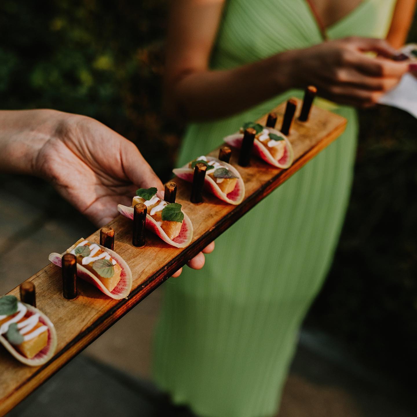 cocktails & canapes board of canapes serving to a guest