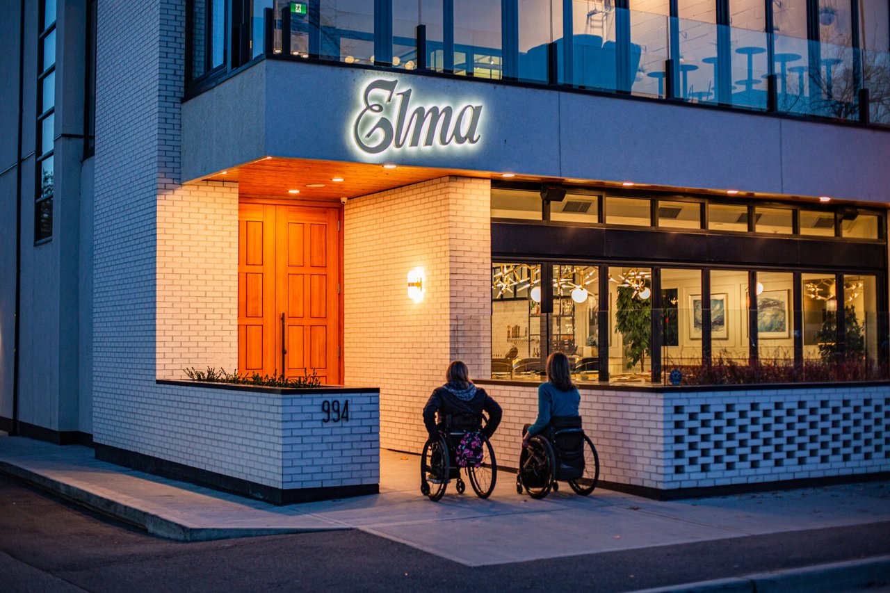 Accessible Tourism - 2 diners in wheelchairs entering Elma Restaurant in Penticton in the evening
