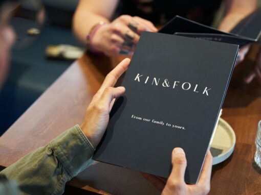Kin & Folk Restaurant menu in diner's hands