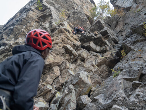skaha bluffs climbing - belayer looking up at rock and climber