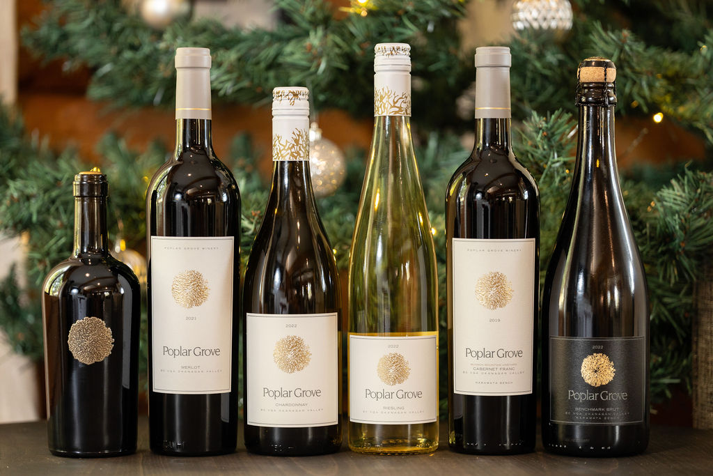 An assortment of Poplar Grove wines in front of a Christmas tree