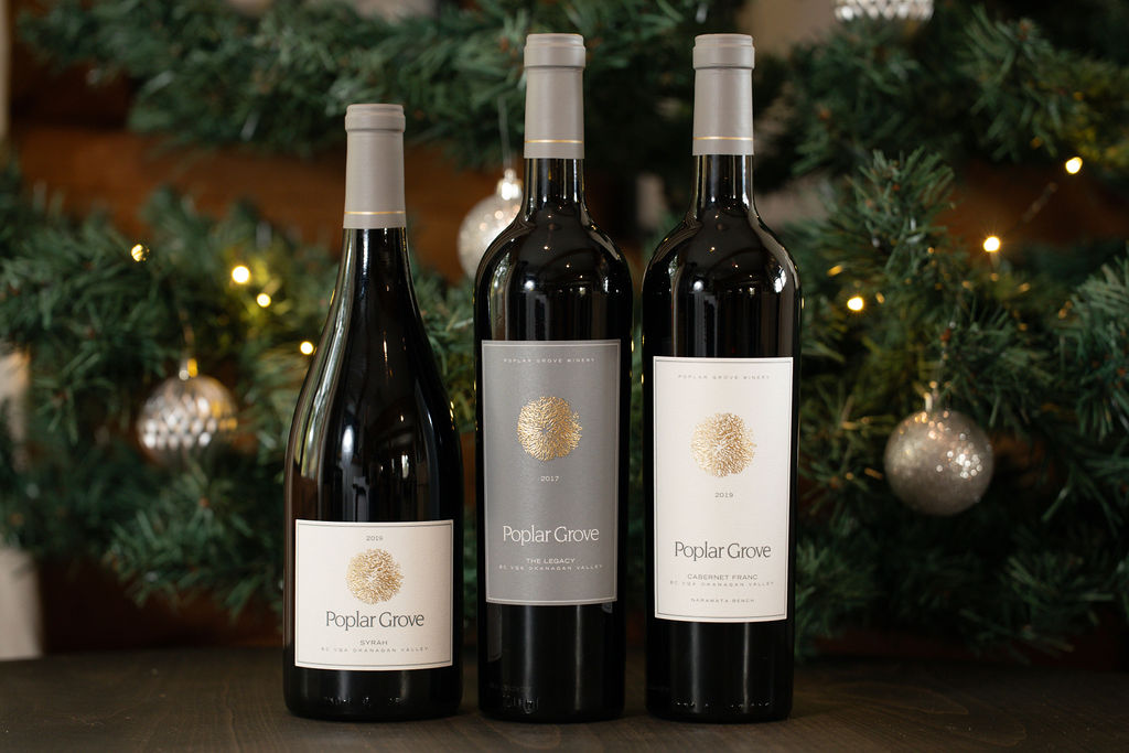 An assortment of Poplar Grove wines in front of a Christmas tree