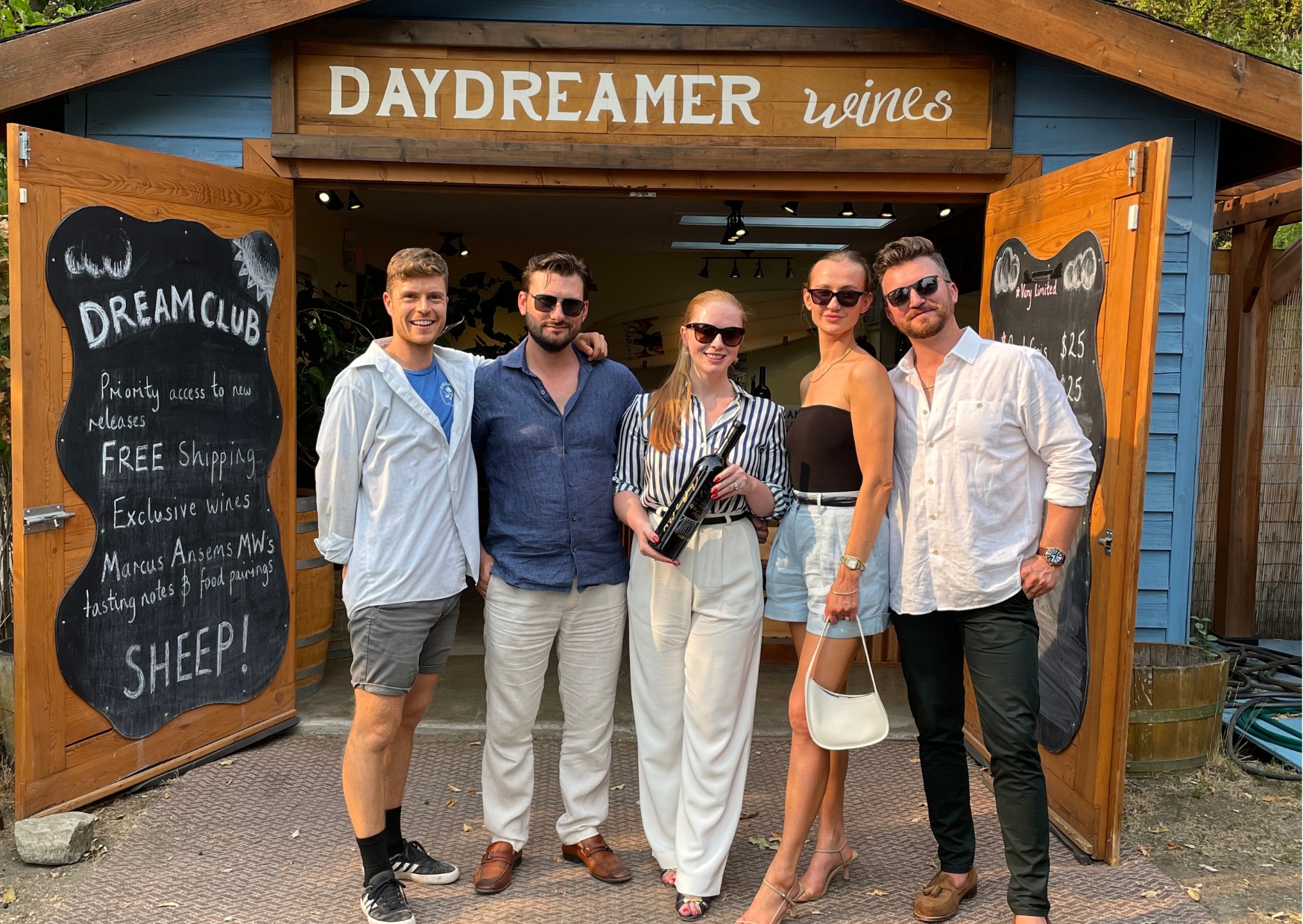 4 Guests along with Tasting Room Manager of Daydreamer Wines in Naramata, BC stand in front of the Wine Shack Tasting Room.